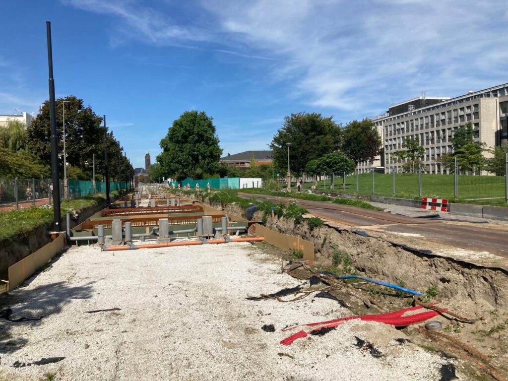 Laying of tram tracks stopped because of supply problems De trambaan op de TU Delft campus in aanleg. Je ziet een uitgegraven weg en stalen balken.