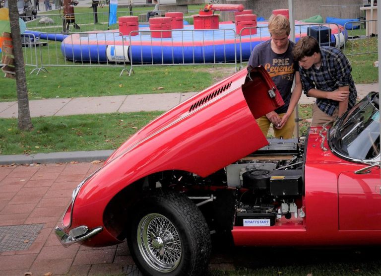 Studenten bij rode auto Lustrum Leeghwater (Foto Roos van Tongeren).jpg