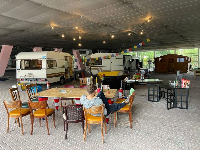 OEBer reclines in the dining area in their encampment, the tables are even adorned with roses.
