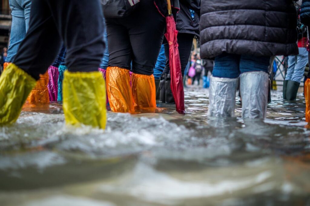 COP28: the hopes and expectations of TU Delft experts People in wellington boots standing in water